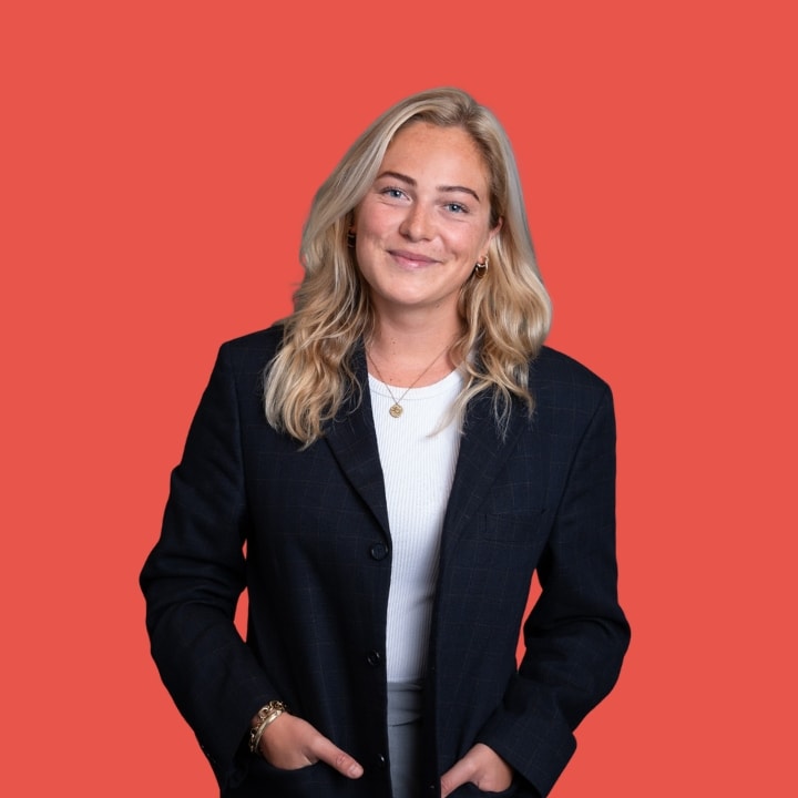 Portrait photo of Sterre Molendijk, founder of Starring, wearing a blazer against an orange-red backdrop