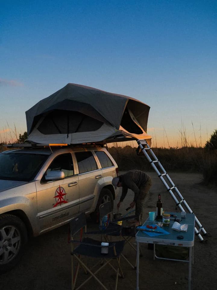 Camping with a rooftop tent at sunset