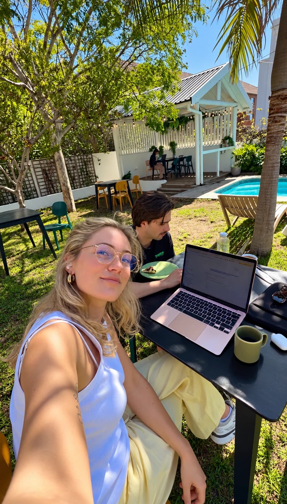 Sterre working on her laptop in a sunny garden